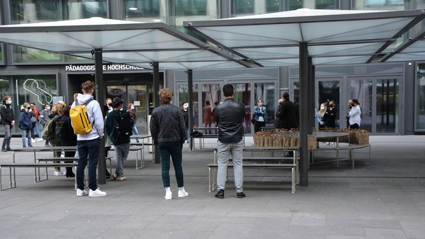 Die Gäste der Vernissage versammeln sich zur Begrüssung im Freien vor den Ausstellungs-räumlichkeiten an der PH Zürich. Jeder Gast erhält im praktischen Papiersack unter Einhaltung des Schutzkonzepts einen «Apéro-to-go».