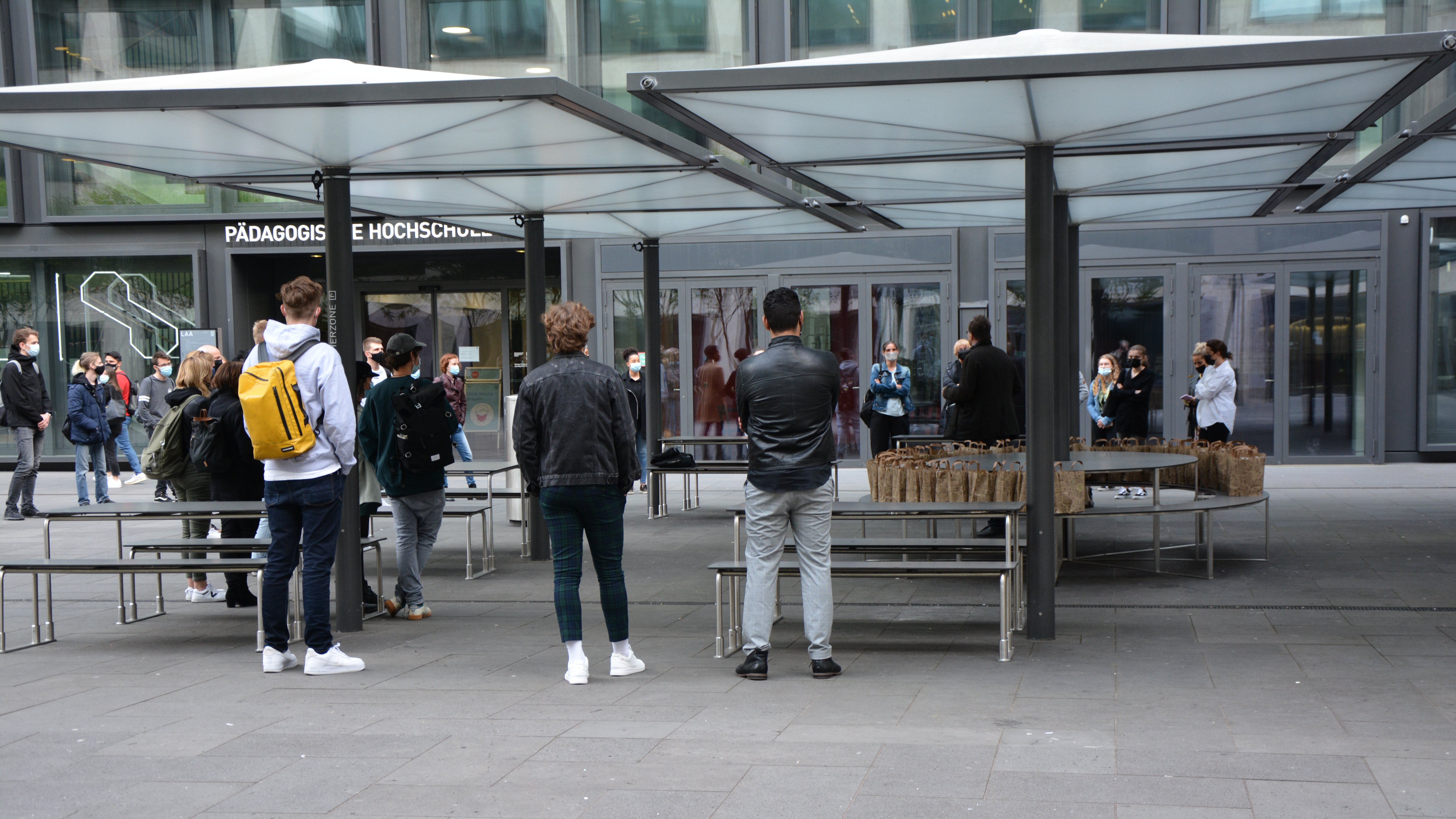 Die Gäste der Vernissage versammeln sich zur Begrüssung im Freien vor den Ausstellungs-räumlichkeiten an der PH Zürich. Jeder Gast erhält im praktischen Papiersack unter Einhaltung des Schutzkonzepts einen «Apéro-to-go». Die Gäste der Vernissage versammeln sich zur Begrüssung im Freien vor den Ausstellungs-räumlichkeiten an der PH Zürich. Jeder Gast erhält im praktischen Papiersack unter Einhaltung des Schutzkonzepts einen «Apéro-to-go».